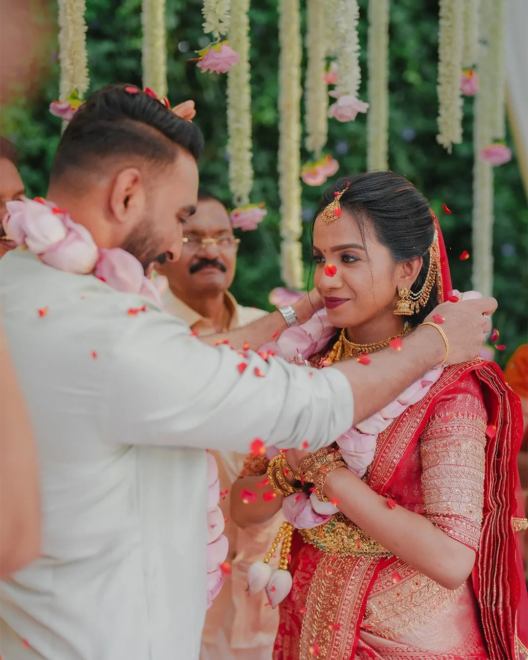 Groom placing a garland on the bride during a Kerala wedding